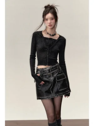 Model wearing a black sparkly faux two-piece cropped knit top with fitted long sleeves, cargo leather mini skirt, sheer stockings and biker boots in an edgy streetwear outfit