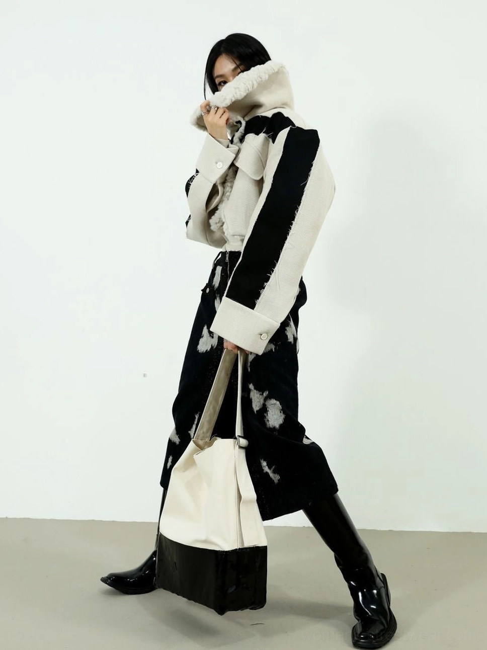 Dynamic streetwear styling of black speckled corduroy midi skirt with color block shearling coat and leather boots