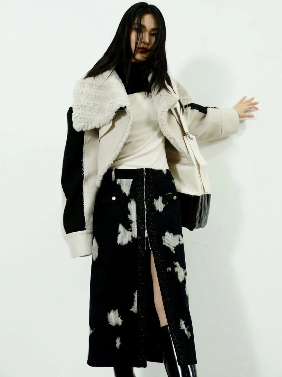 Women's black speckled corduroy midi skirt with front zipper slit styled with a matching shearling trim coat
