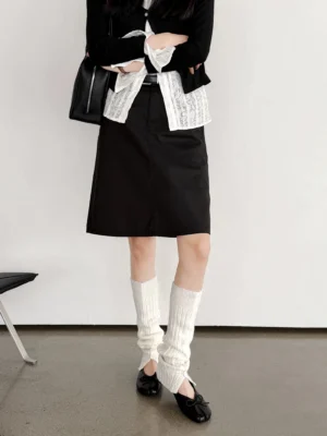 Model wearing black split-toe leather ballet flats with knit leg warmers and layered streetwear outfit