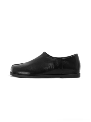Black split-toe leather loafers shown from the left side on a white background with a minimalist low-cut slip-on silhouette