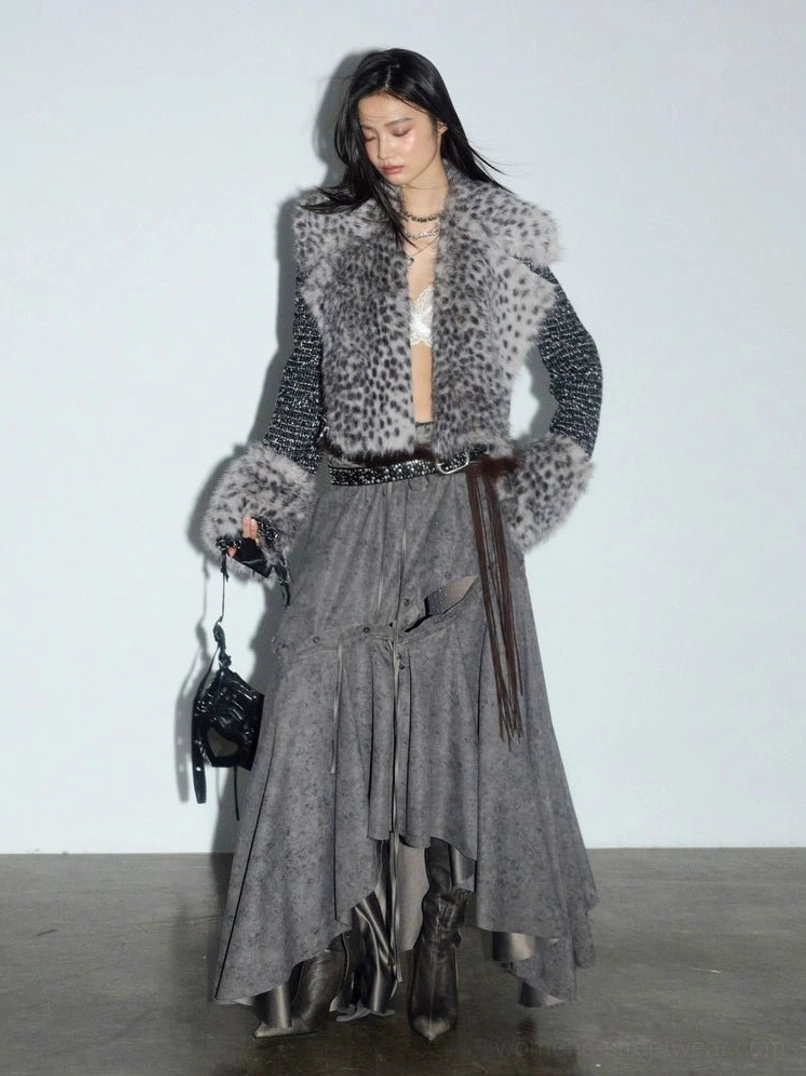 Close front view of a black cropped tweed jacket with grey spotted faux fur panels, collar, and cuffs