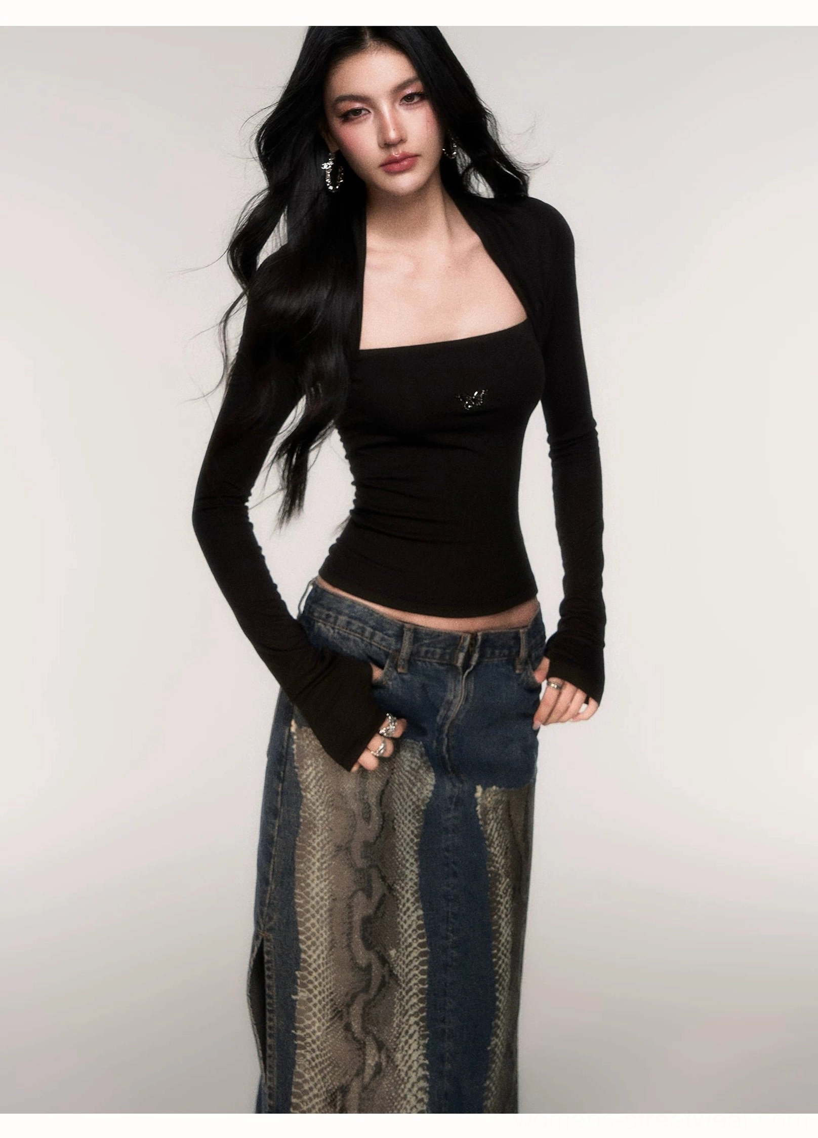 Black square neck ribbed knit top with subtle metal butterfly emblem, fitted body, long sleeves, and patched denim styling