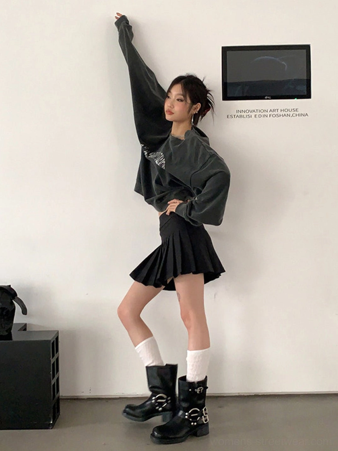 Full side view of black square-toe Western boots with double buckles worn with a casual Y2K mini skirt outfit