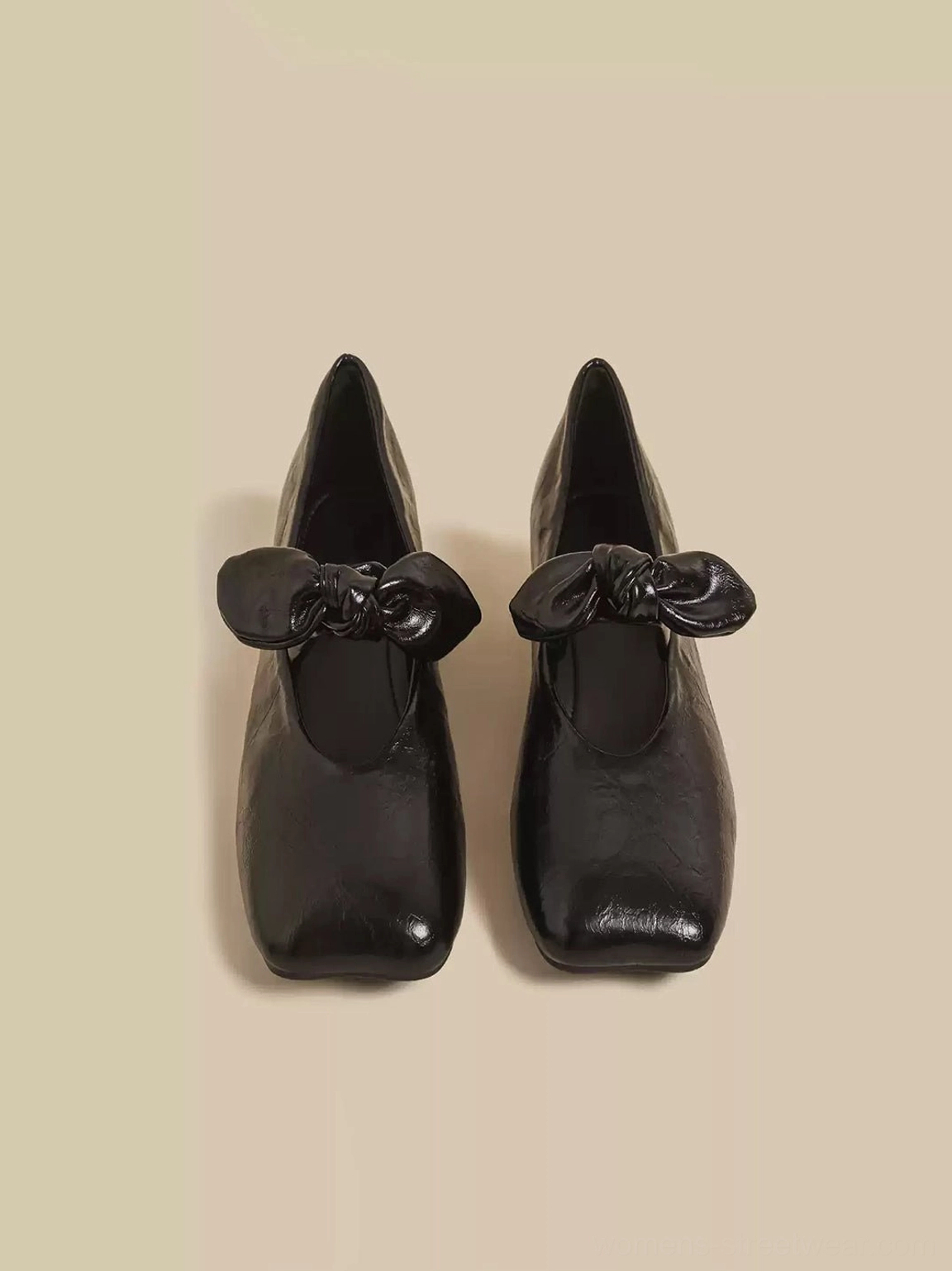 Black square-toe Mary Jane flats with structured bow detail and textured finish displayed in an alternate top-down view