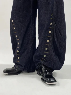 Black square-toe platform derby shoes styled under dark indigo wide-leg denim in a low-angle streetwear outfit view