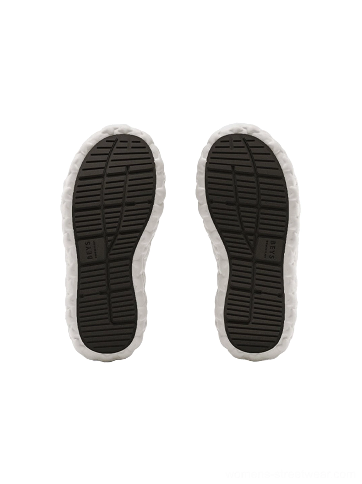 Top-down view of black star platform sandal outsoles showing non-slip lug tread textured footbed and light gray rubber border