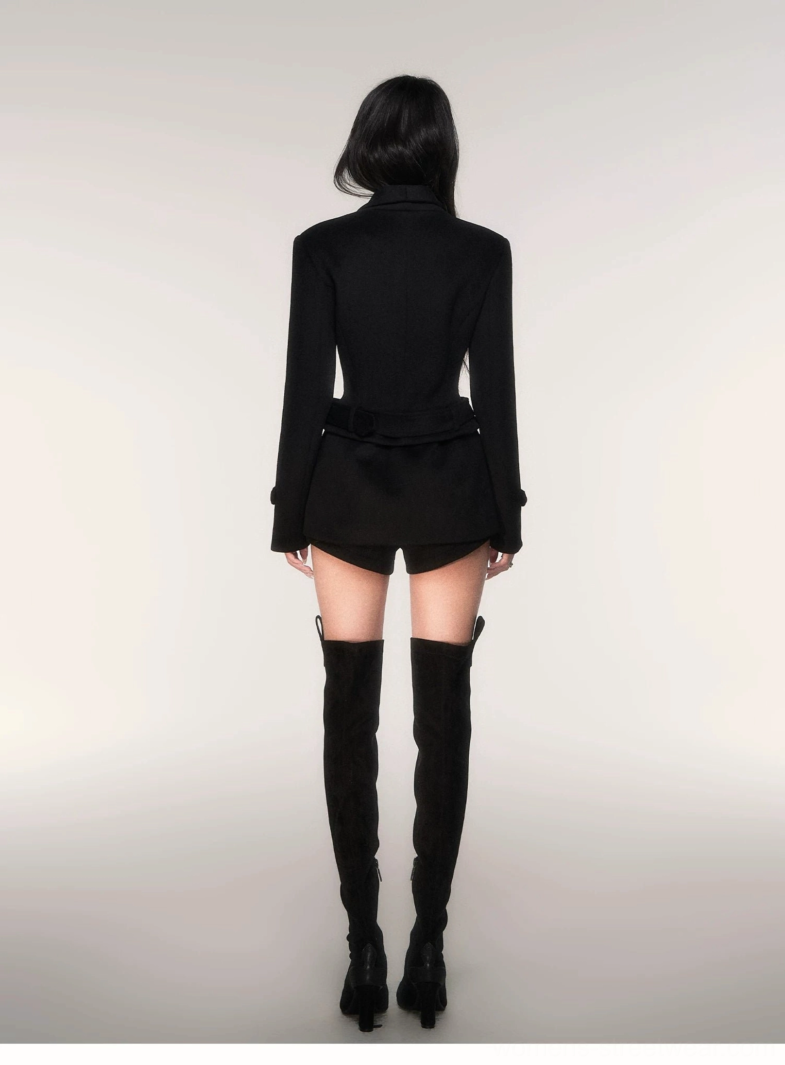 Back view of black structured shoulder belted wool blend peacoat showing tailored waist silhouette
