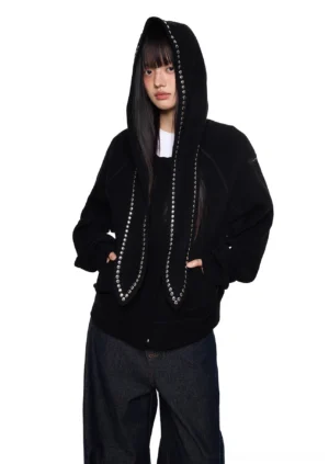 Black oversized bunny ear hoodie with silver studded hood ears styled with wide-leg jeans in a front three-quarter streetwear outfit