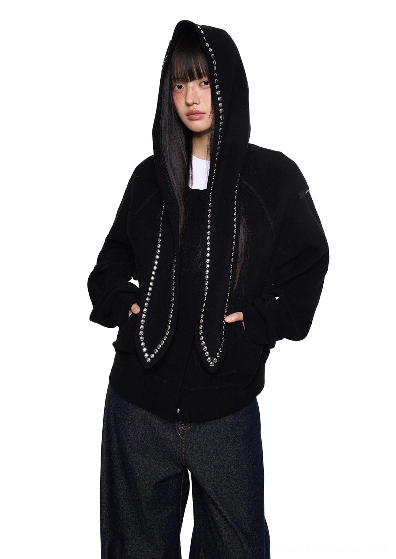 Black oversized bunny ear hoodie with silver studded hood ears styled with wide-leg jeans in a front three-quarter streetwear outfit