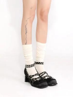 Black studded Mary Jane heels styled with off-white slouch socks, double-row buckle hardware, and bold spiral block heels in a streetwear outfit