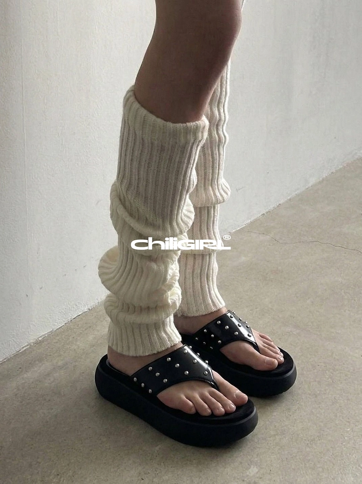 Black studded platform sandals contrasted with cream ribbed leg warmers