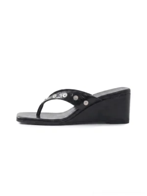 Black studded platform thong sandals with glossy PU straps, polished silver studs, square open toe, and low wedge sole shown in a side product view