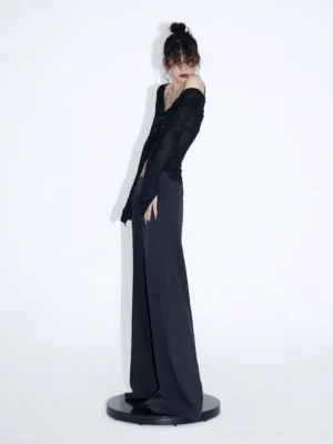 Back view of black studded ribbed button cardigan top with fitted long sleeve silhouette and dark wide leg trousers