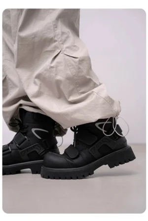 Black tactical platform combat boots worn with loose gray cargo pants shown from a low rear angle