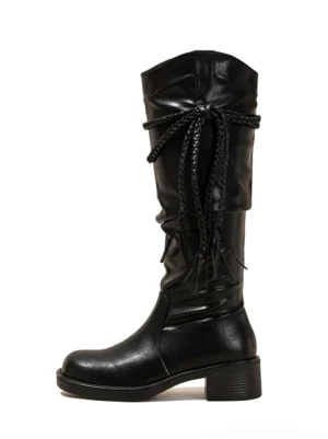Black tassel lace over-the-knee riding boots in left side view with slouchy microfiber shaft and low chunky block heel