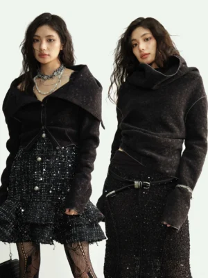 Black textured cowl-neck cropped knit cardigan styled with a sparkly tweed skirt and layered silver necklaces in a front three-quarter studio view