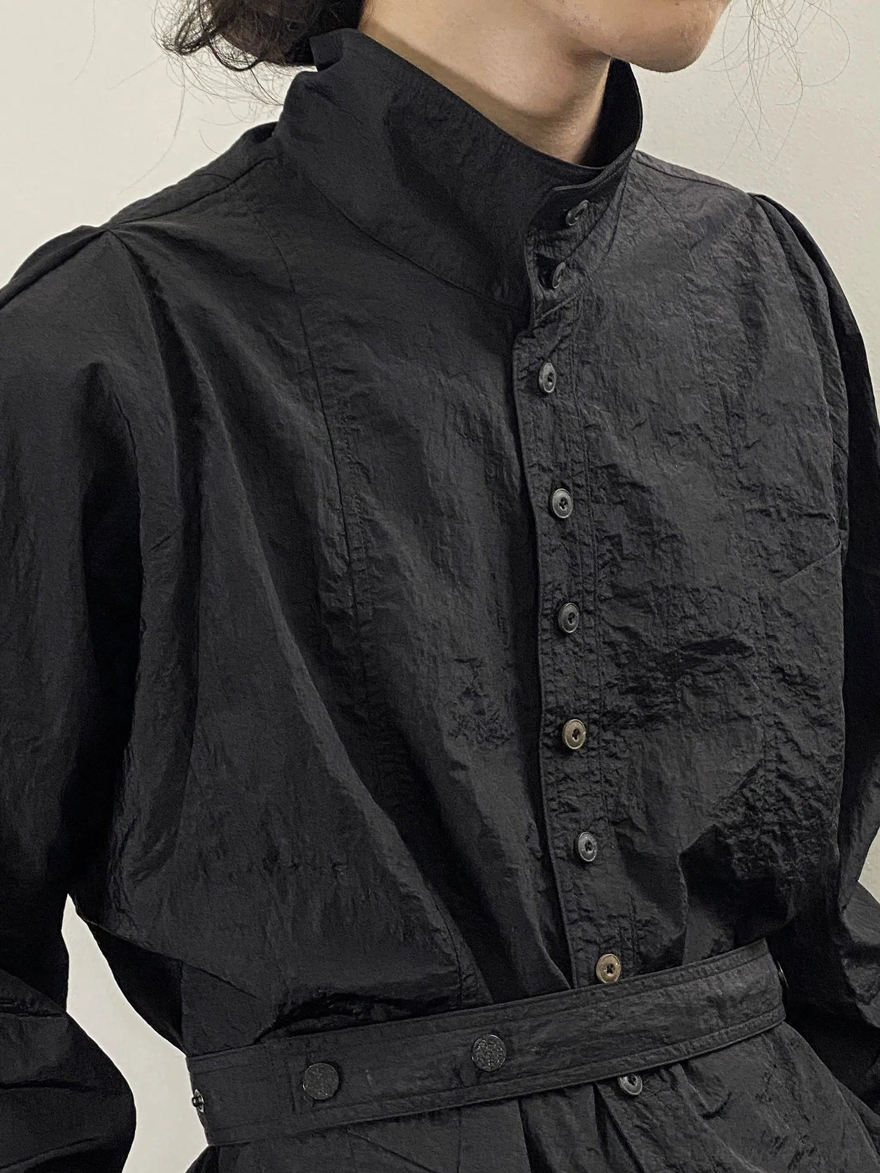 Black textured stand collar oversized shirt styled with tailored black trousers in an avant-garde streetwear look