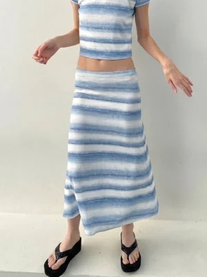 Women wearing black toe-ring platform wedge flip-flops with a striped crop top and wrap skirt streetwear outfit