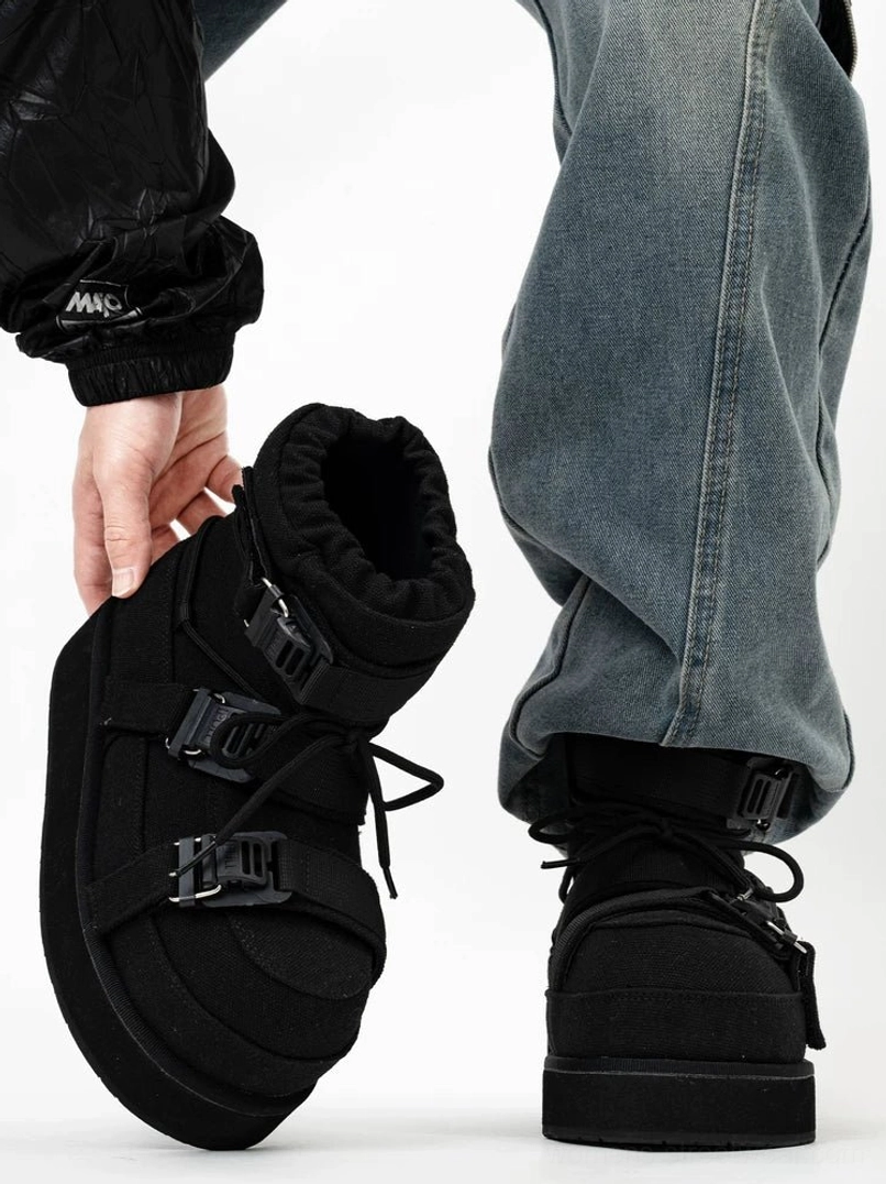 Black triple-buckle platform snow boots worn with blue jeans, showing padded moon-boot silhouette, side profile, back view, lace-up front and fleece collar