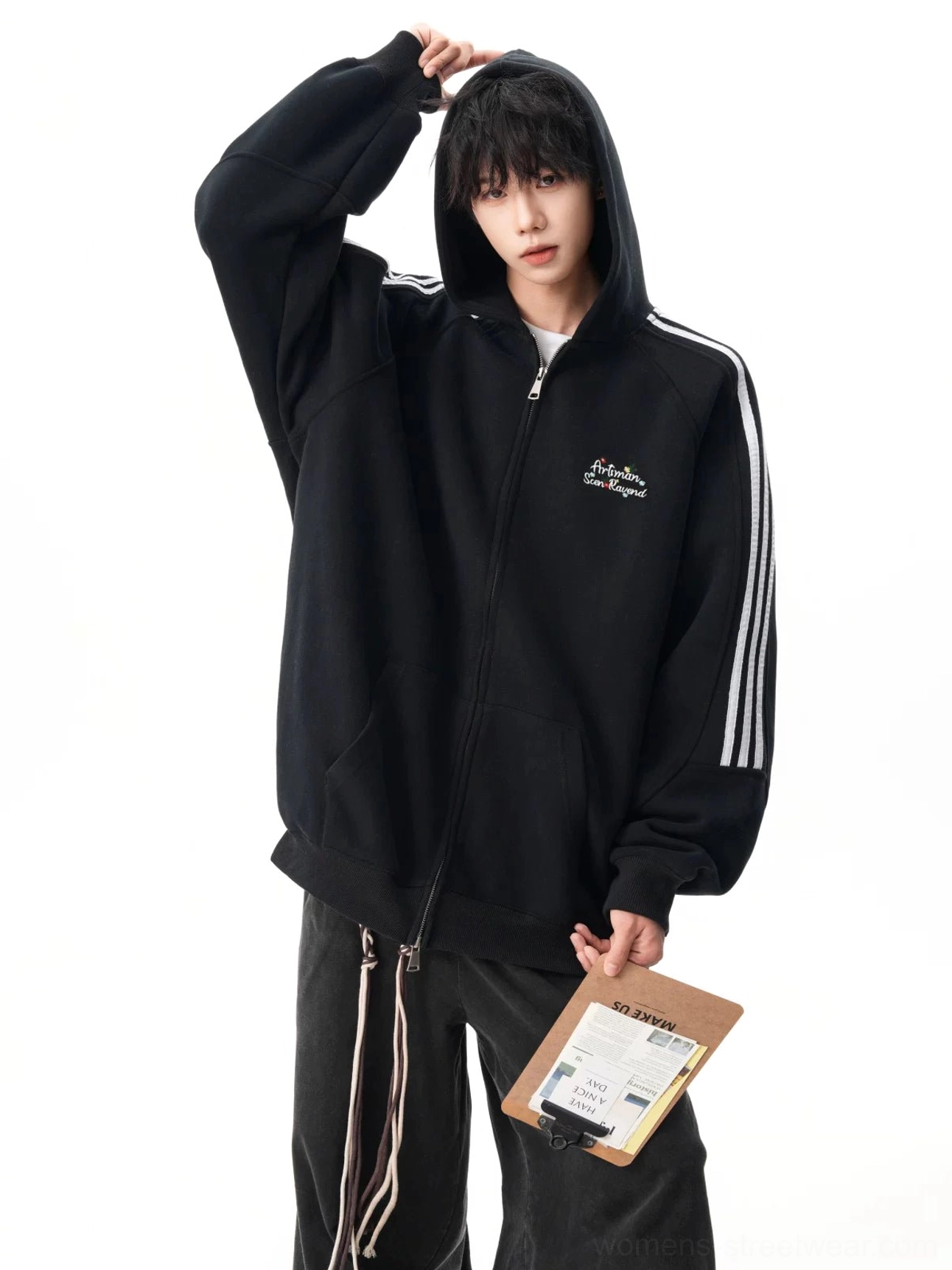 Front view of black triple stripe zip-up hoodie with adjustable hood, full zipper closure, embroidered chest detail, and loose sleeves