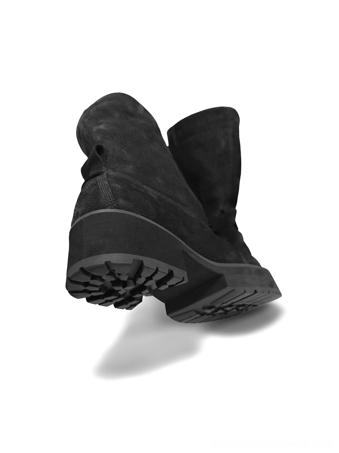 Rear bottom view of black tumbled leather slouch boots highlighting the thick anti-slip molded rubber outsole and relaxed mid-calf silhouette