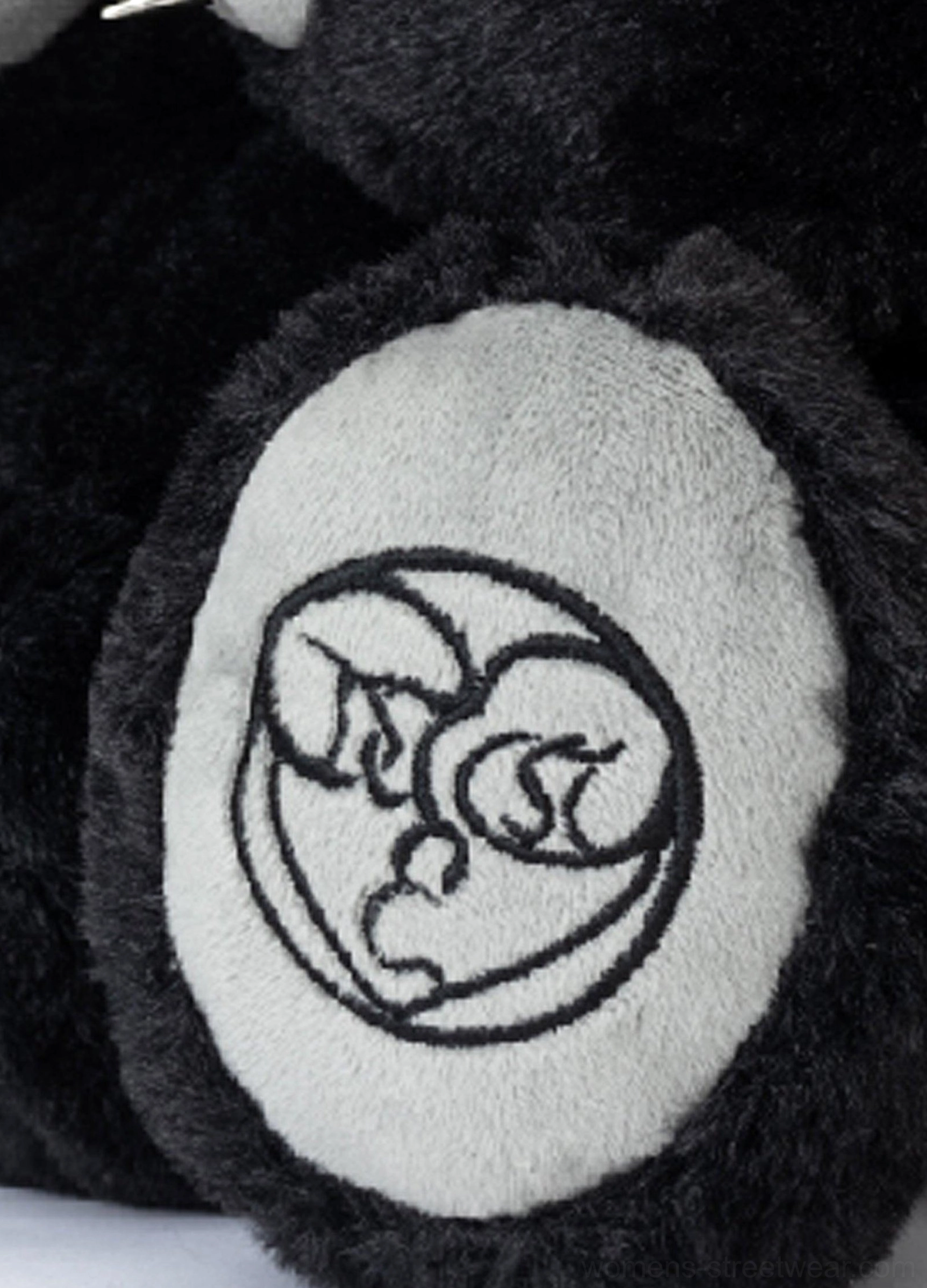 Close-up of soft grey embroidered paw pad detail on the black twin evil bear faux fur mini backpack