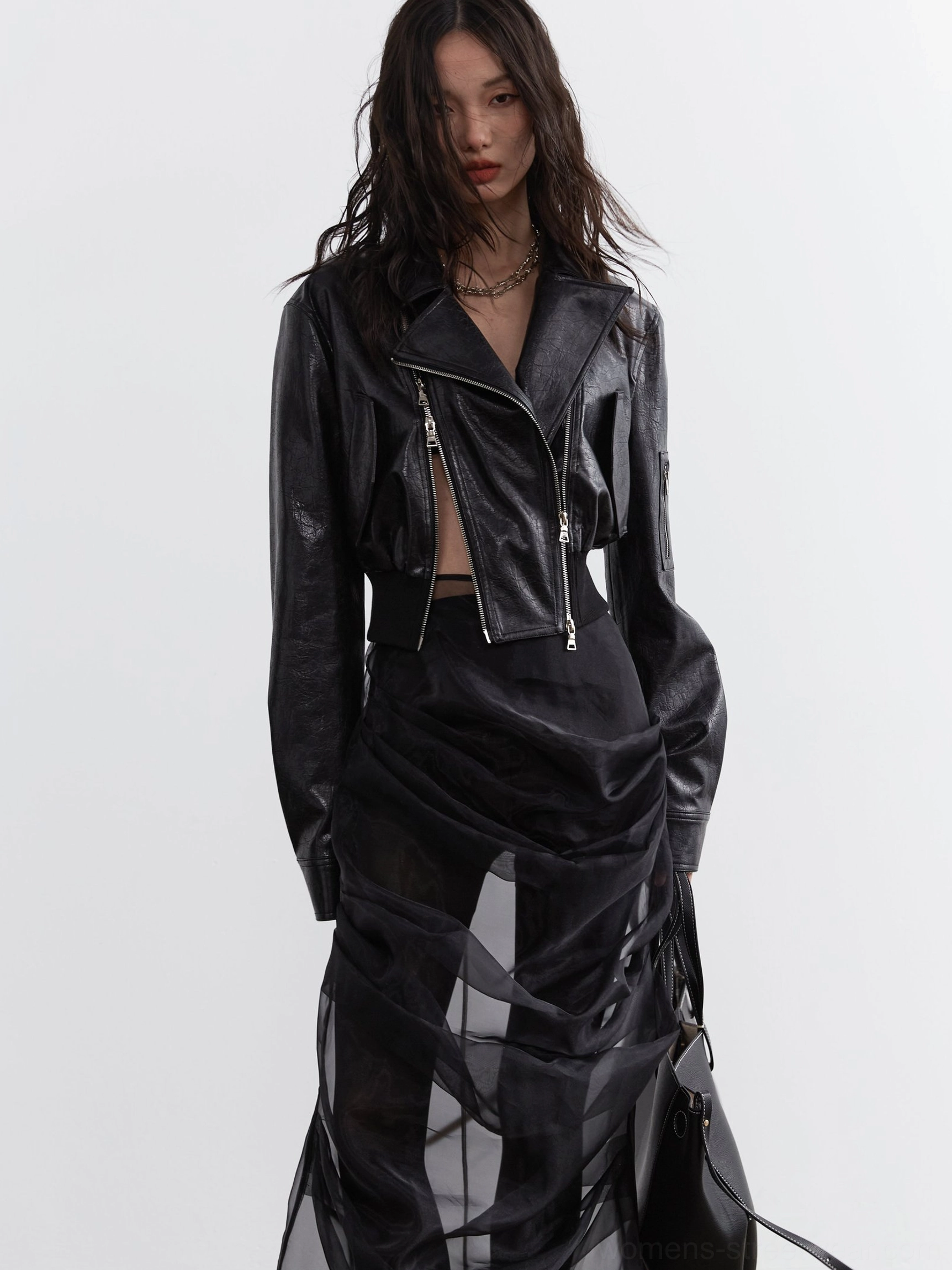 Front view of a black ultra-cropped biker jacket with structured shoulders, smooth faux leather finish, wide ribbed waist hem, and contemporary women's streetwear silhouette