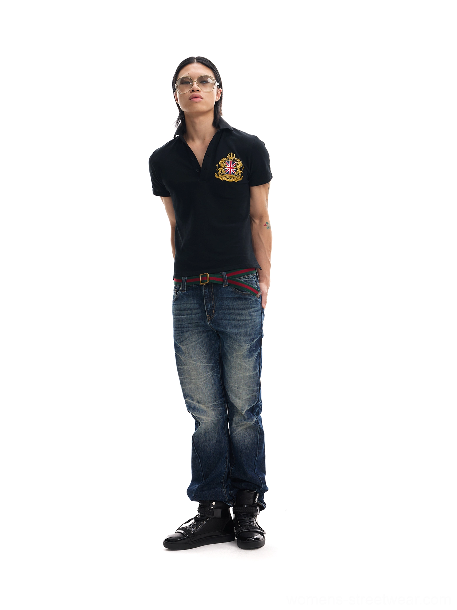 Black embroidered crest graphic back polo shirt styled with distressed jeans and leather boots front view