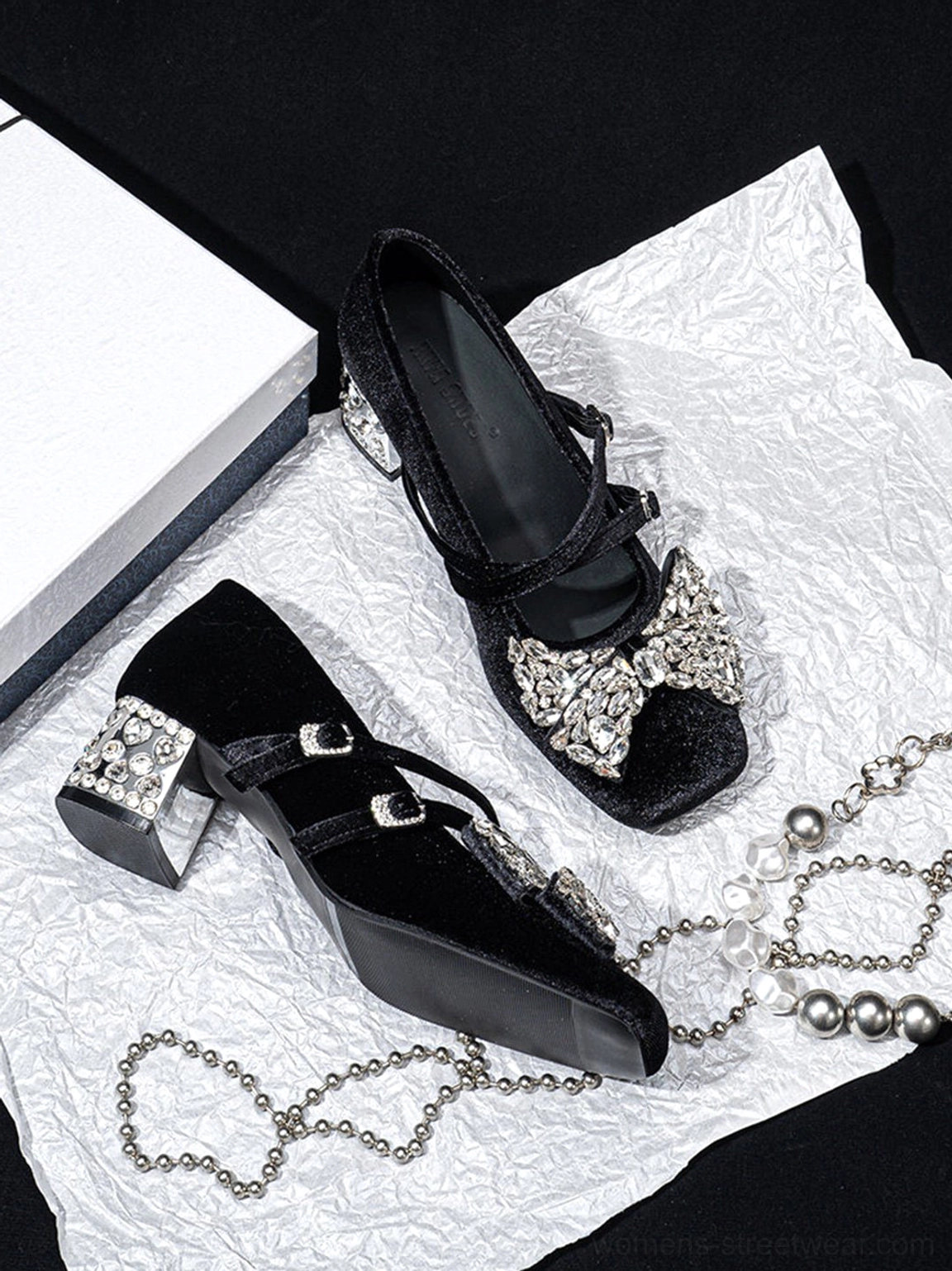 Pair of black velvet crystal bow block heel Mary Jane pumps flat lay with silver rhinestone chain