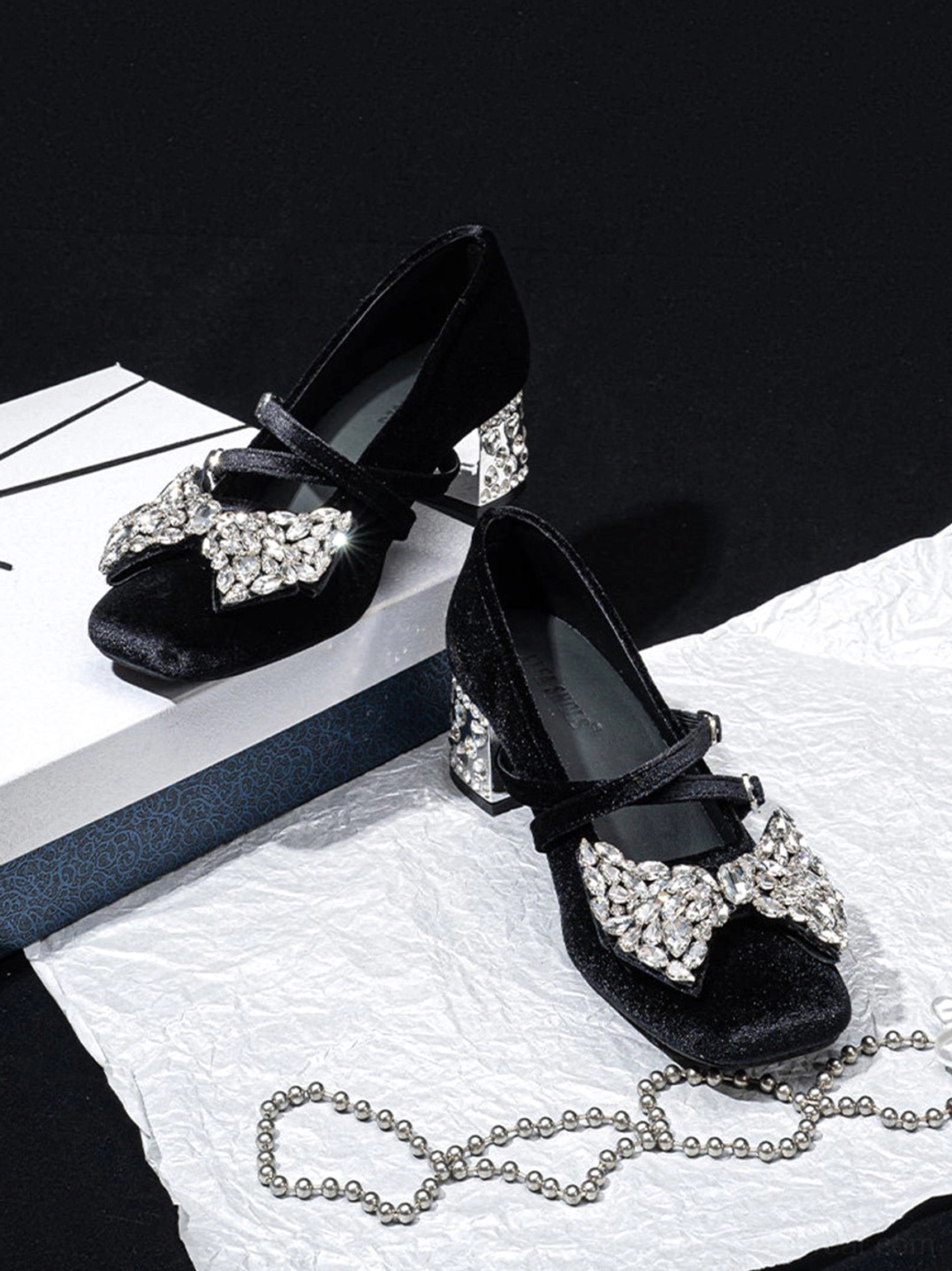 Three quarter overhead view of black velvet crystal bow block heel Mary Jane pumps