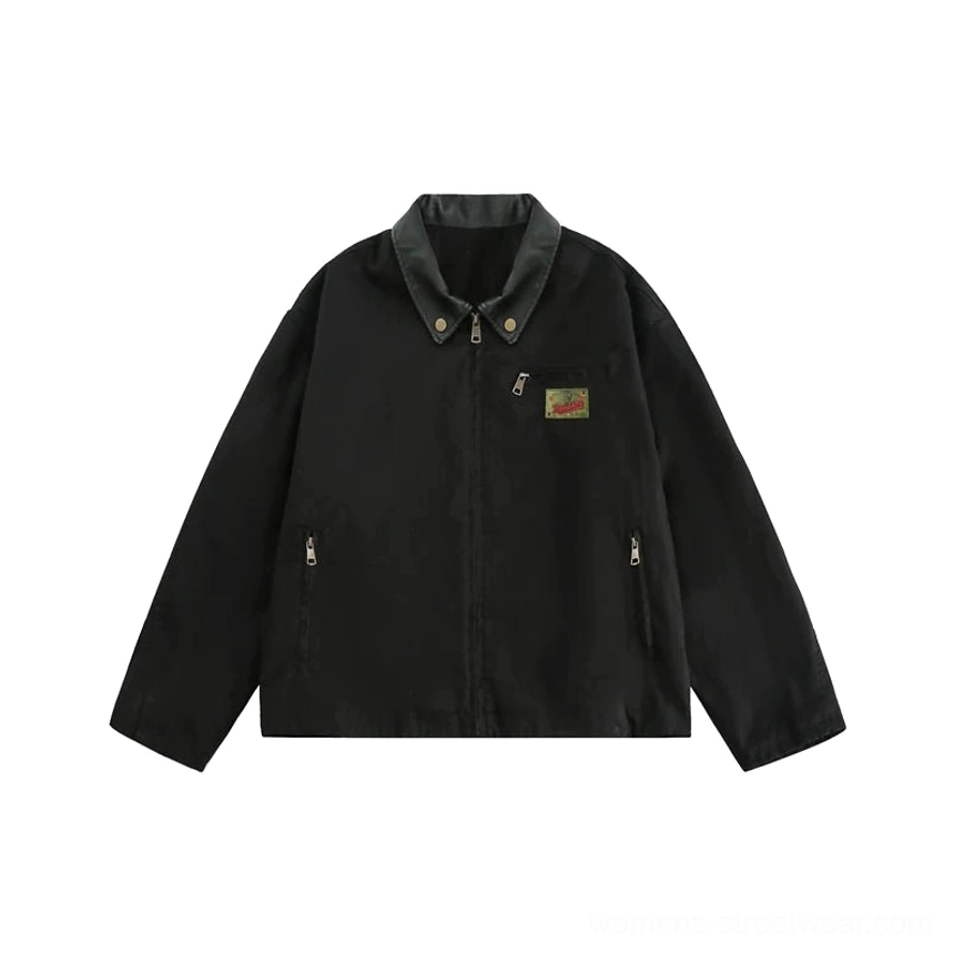 Flat lay of a black vintage cargo work jacket showing contrast collar, embroidered chest patch, front zipper, and two side pockets