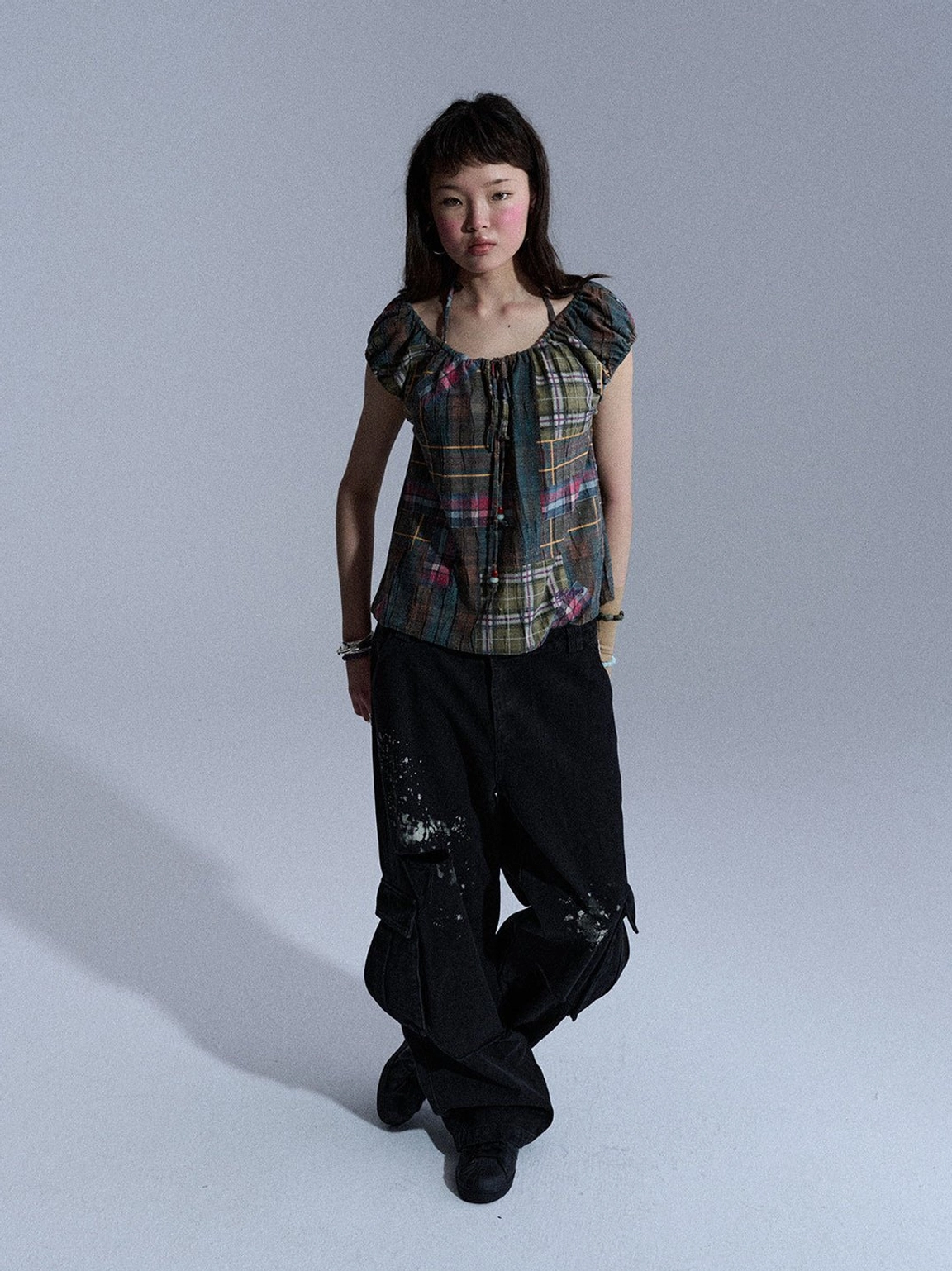 Black vintage washed cargo denim pants with wide-leg streetwear fit, ripped cutouts, paint accents, and utility pockets