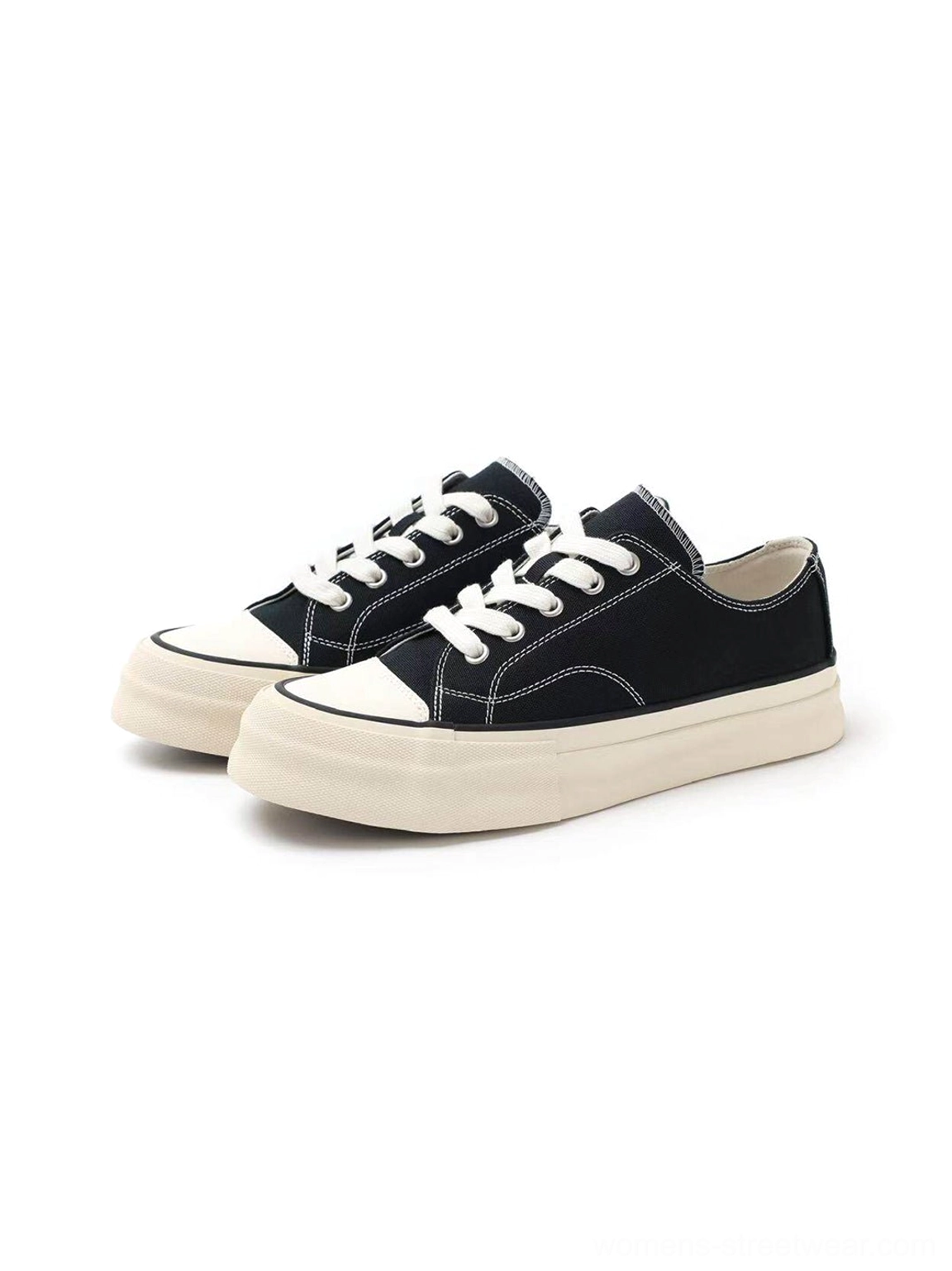 Three-quarter front view of black vulcanized canvas platform sneakers with round rubber toe caps white laces and contrast soles