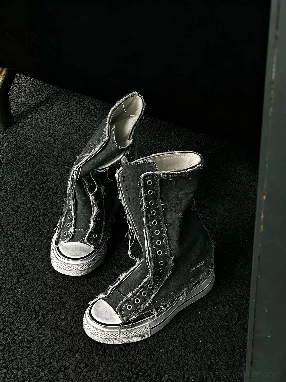 Black washed distressed high-top canvas platform boots displayed from a low angle on dark asphalt