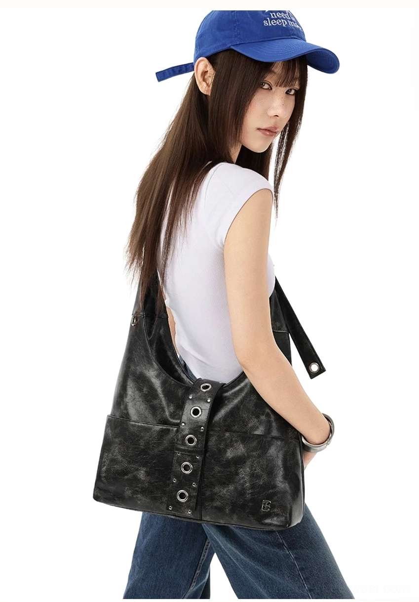 Black washed faux leather rivet hobo shoulder bag worn from rear three-quarter view