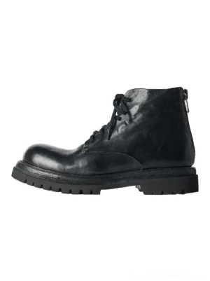 Black washed horsehide rear-zip combat boot shown from a left three-quarter angle with front laces, round toe, vintage leather texture, and chunky lugged rubber outsole