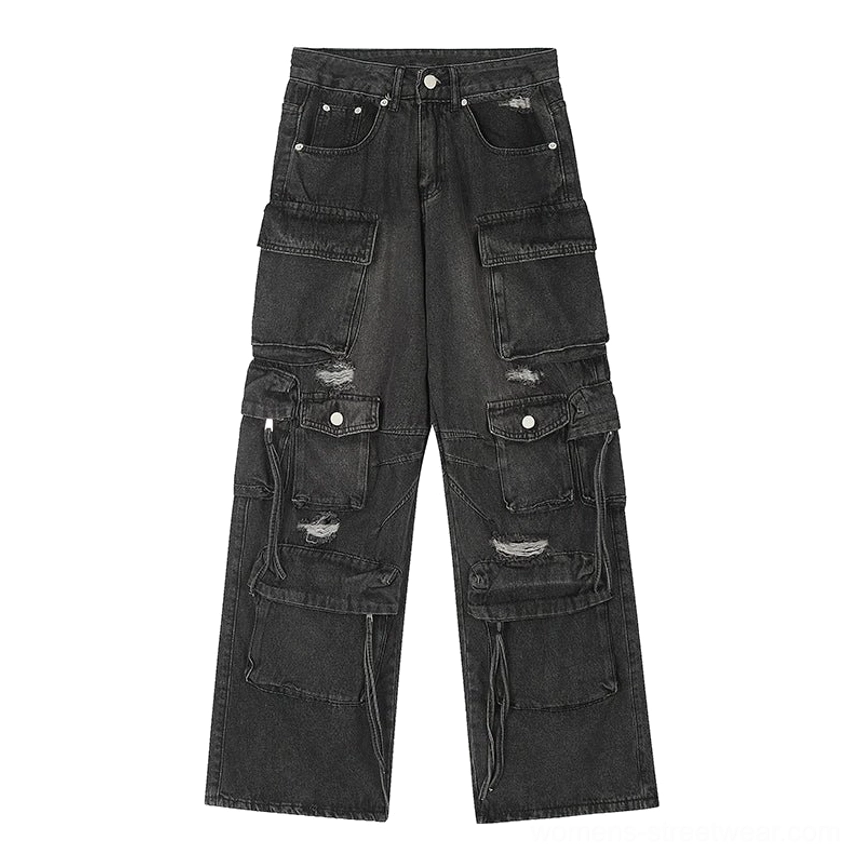 Flat lay front product view of black washed multi-pocket wide-leg cargo jeans with distressed rips, metal hardware, and drawstring details