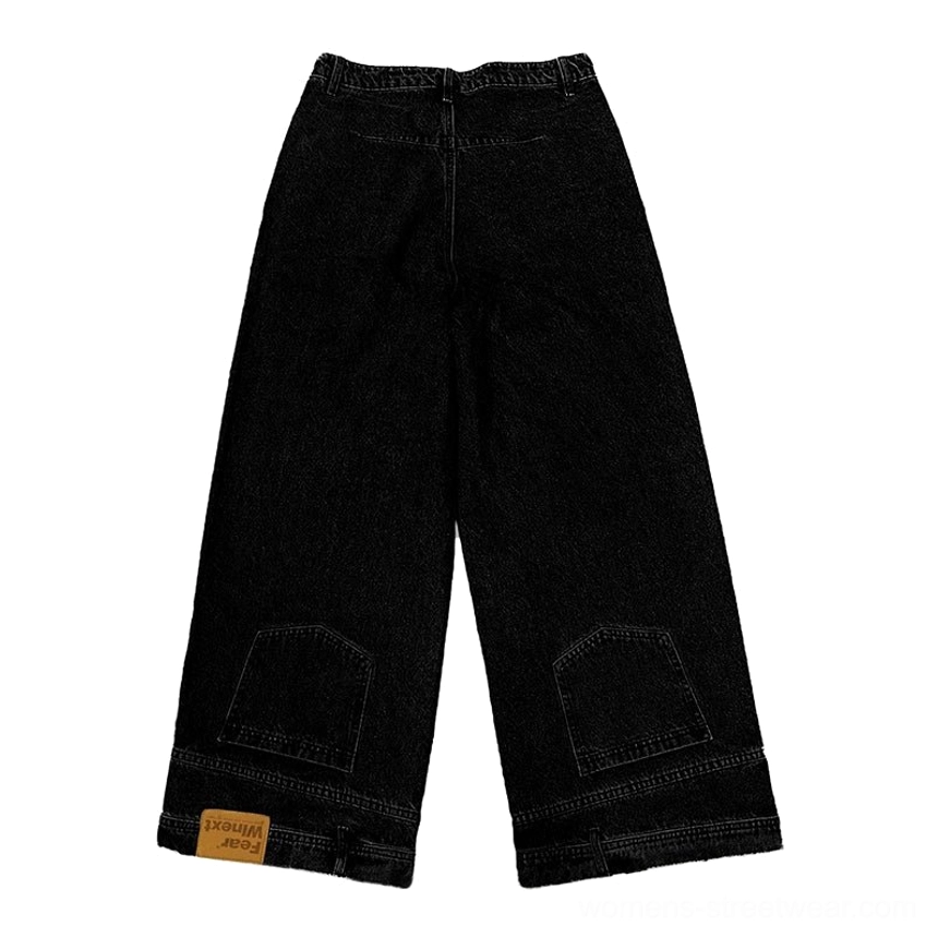 Flat lay front view of black women’s wide-leg cropped jeans with washed denim finish, lower-leg patch pockets, layered hem, and modern streetwear design