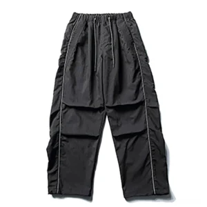 Front flat lay of black water-resistant reflective utility cargo pants with elastic drawstring waist pleated front and oversized wide-leg techwear silhouette