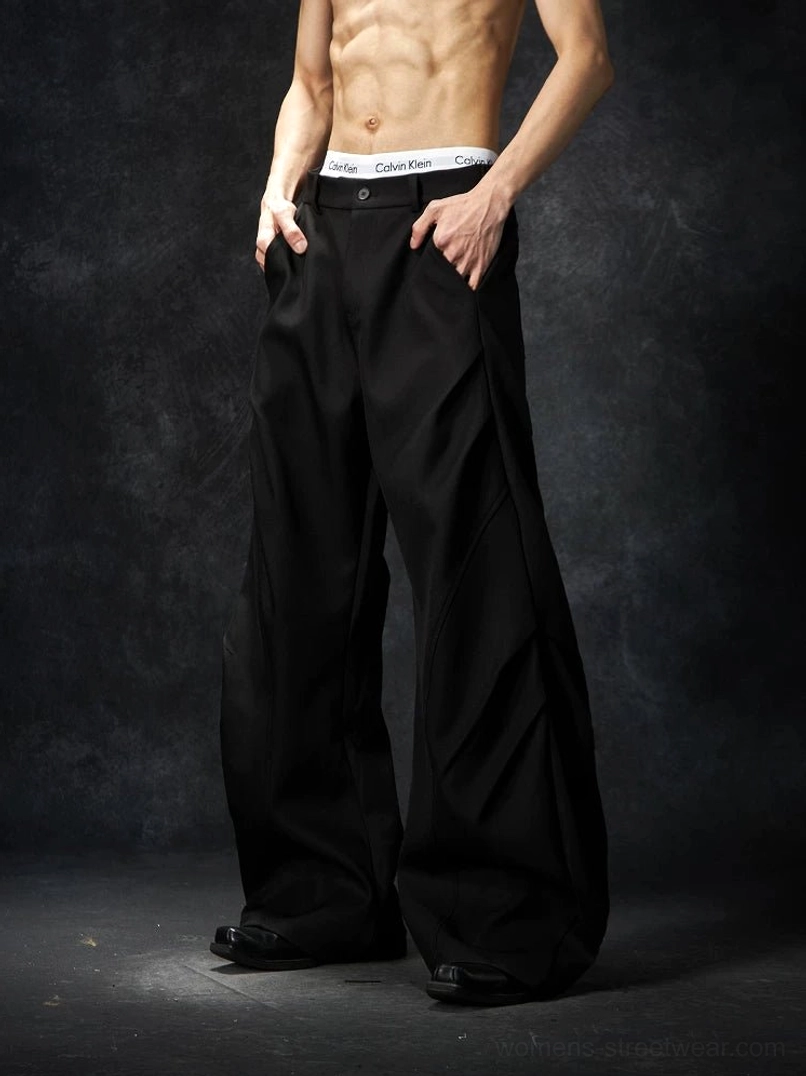 Black wave contour wide-leg streetwear trousers shown in a waist-focused front view with a clean waistband and structured extra-wide legs