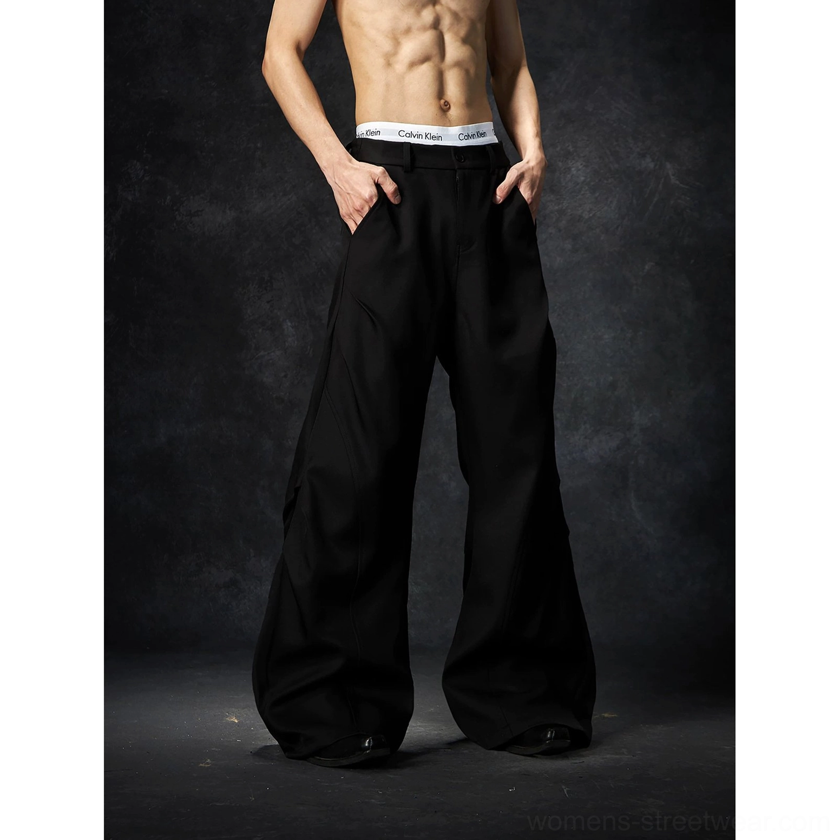 Black wave contour wide-leg trousers product image showing the structured waistband and dramatic streetwear silhouette