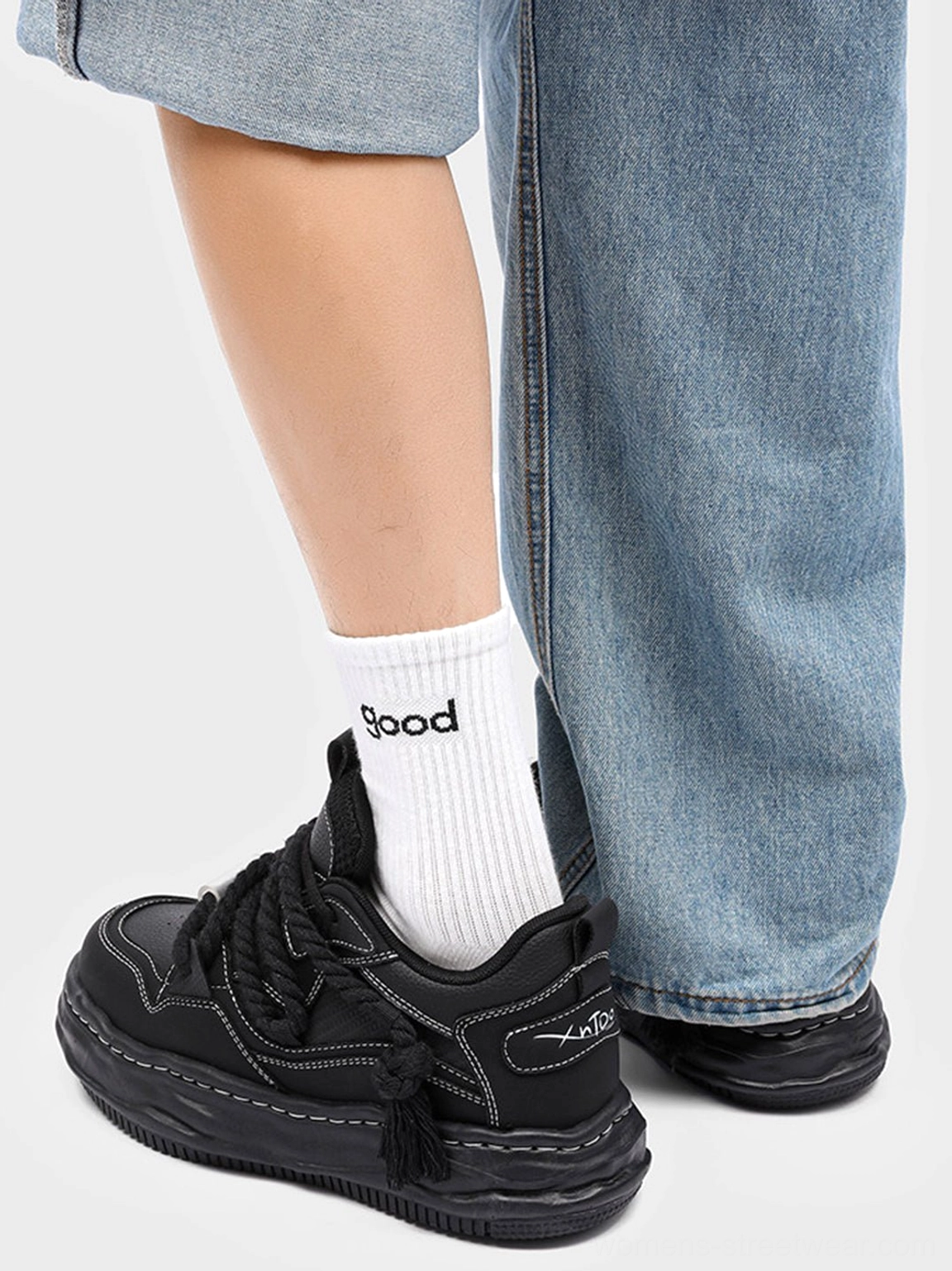 Rear view of black wavy platform sneaker showing structured upper stitched details and raised outsole