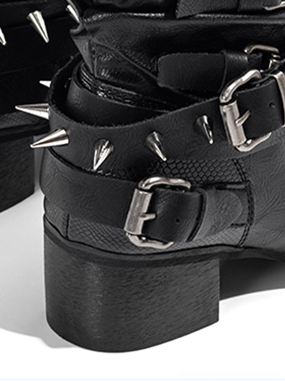 Close-up of black western boot silver buckle strap metal studs and textured synthetic upper