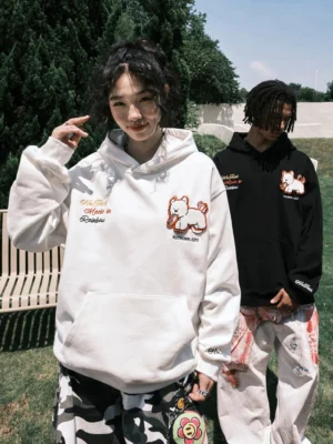 Black and white embroidered dog oversized hoodies styled on two models outdoors with casual cargo pants, showcasing playful puppy graphics and relaxed Korean streetwear silhouettes