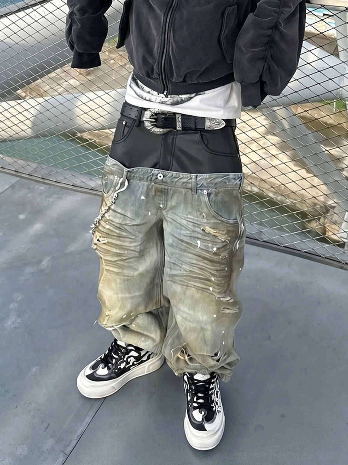 Black and white flame skull platform sneakers styled with distressed wide leg denim and cropped jacket in an urban streetwear setting