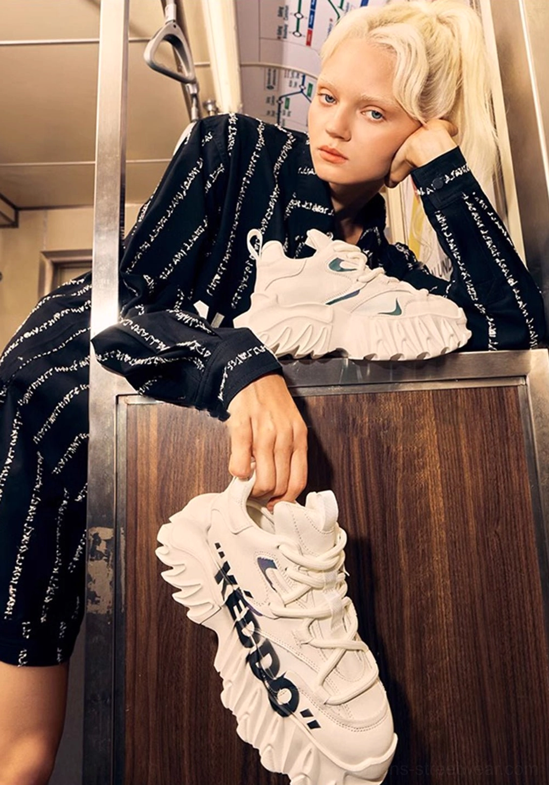 Black and white chunky graphic platform shoes displayed in a subway-style setting with streetwear outfit