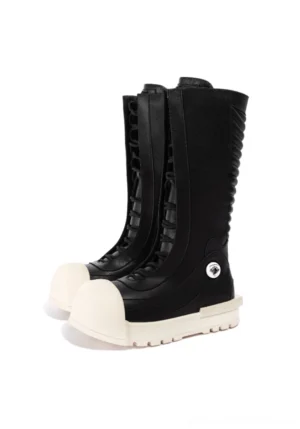 Front three-quarter view of black streetwear platform boots with rounded off-white toe caps, lace-up fronts, thick soles, and silver ankle details