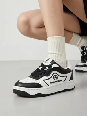 Black and white chunky skate sneakers worn with cream mid-calf socks in a casual streetwear outfit