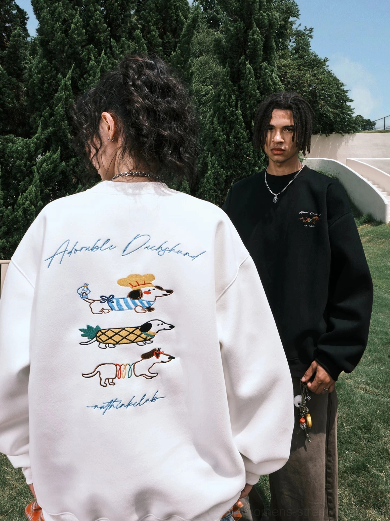 Black and white oversized dachshund graphic sweatshirts modeled from the rear with matching colorful back embroidery-style streetwear designs